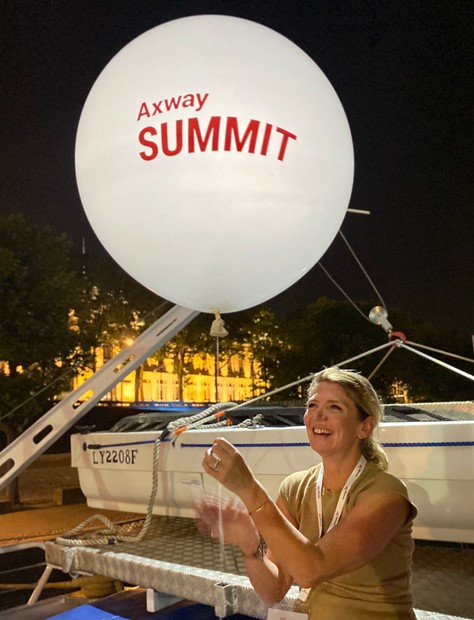 Hanissa Khodri holds an Axway Summit balloon aboard the evening boat at Axway Summit 2024 in Lyon, France