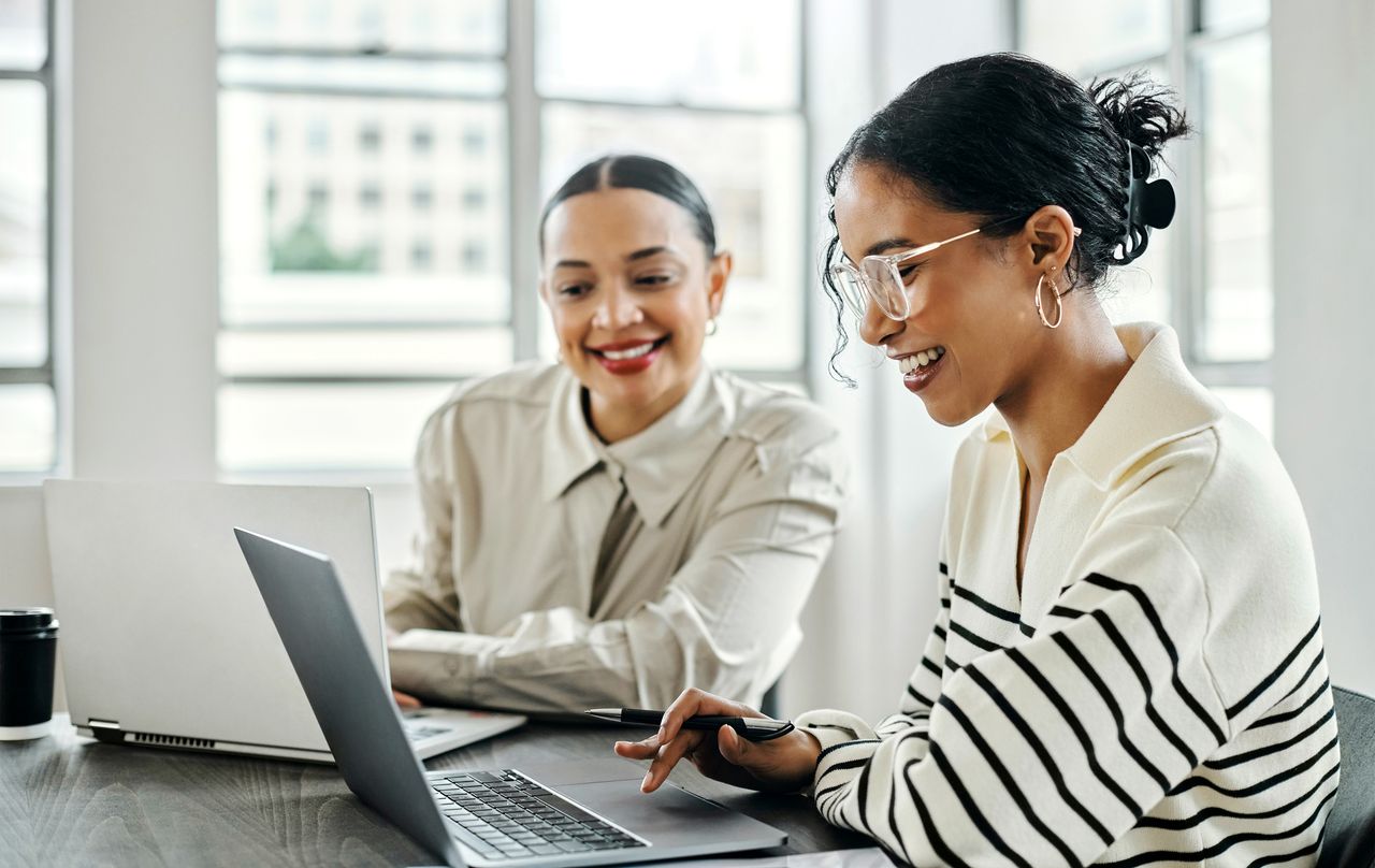 Business women, laptop and and happy team in office for web design, collaboration and training. Planning, digital marketing and coaching by woman leader menor help, explain and support creative goal