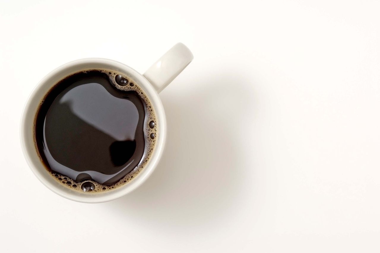 a cup of coffee seen from above on a white table
