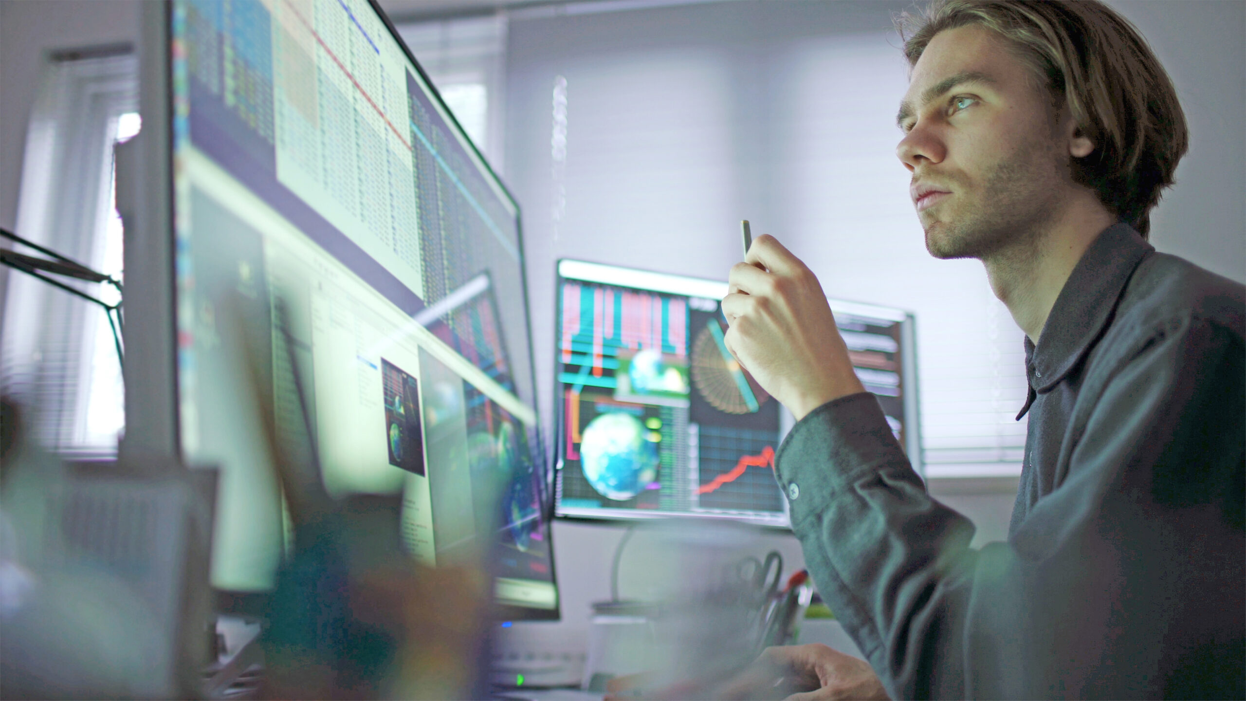A web developer sitting in front of a computer looking at the screens