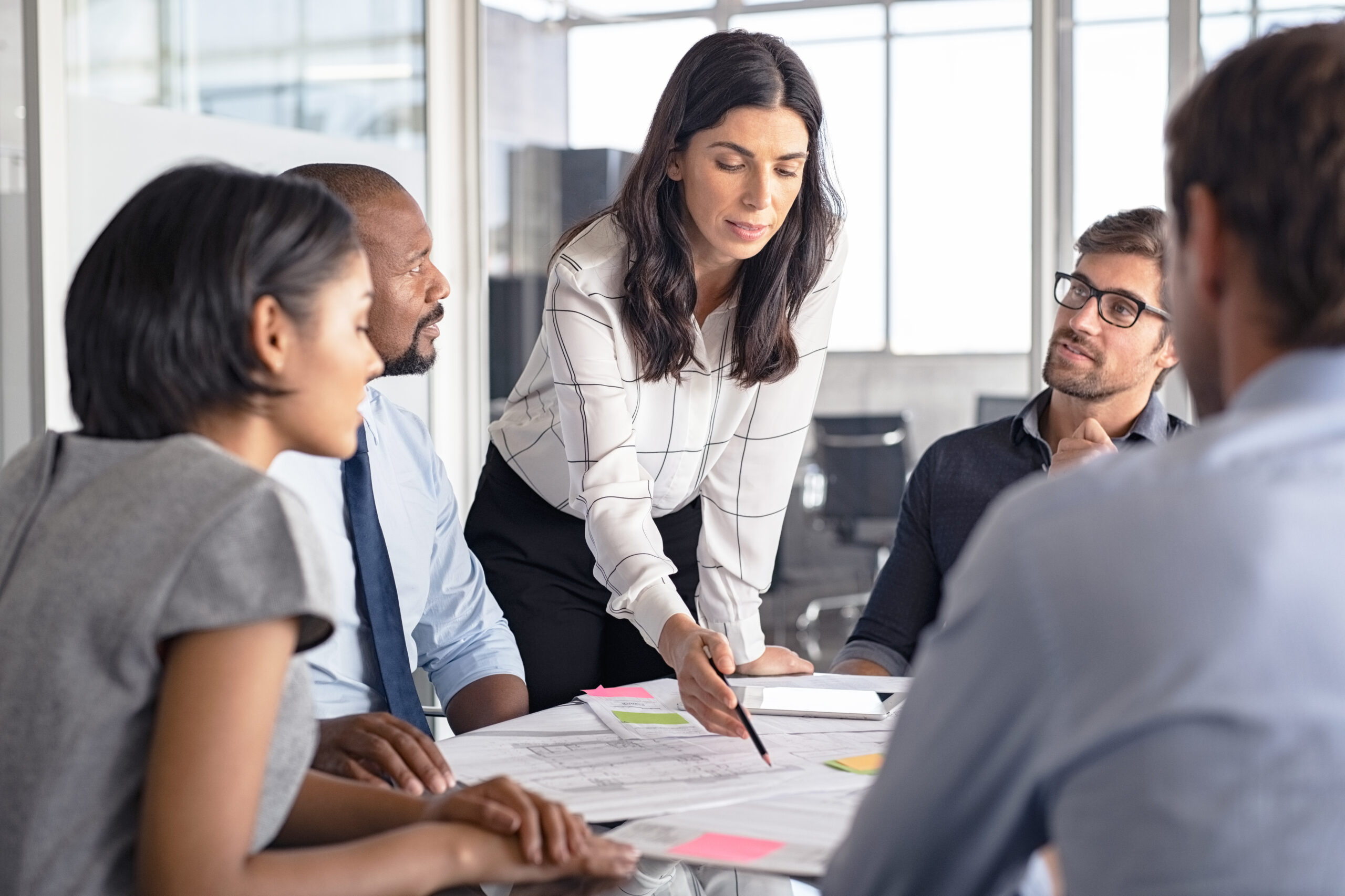 Architect working on blueprint with team