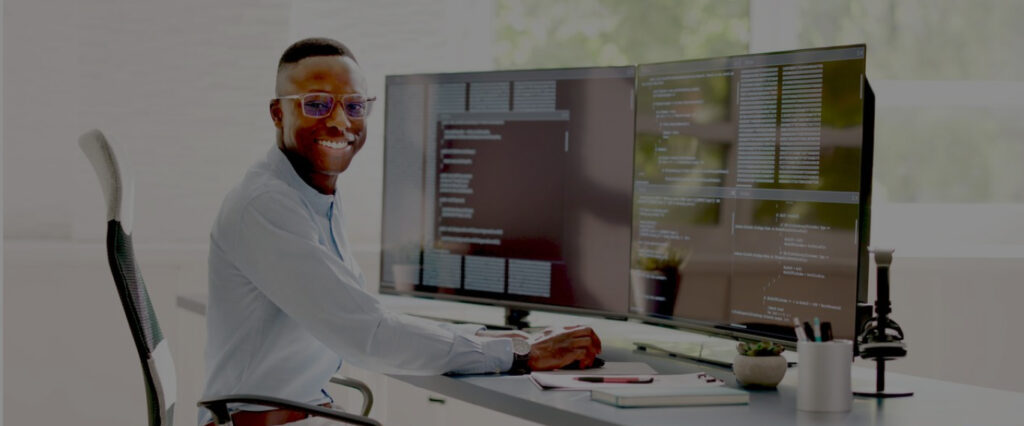 Coder at desktop monitors