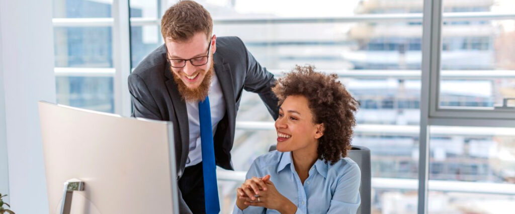 Man and a woman talking in front of a computer